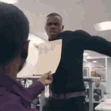a man in a black shirt is holding a piece of paper over his head