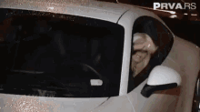 a woman is sitting in a white sports car with the word prva.rs on the bottom right corner .
