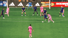 a group of soccer players are playing on a field with an adidas ad behind them