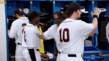 a group of baseball players in a locker room with one wearing the number 10