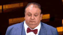 a man wearing a suit and bow tie looks down