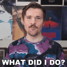 a man with a beard is wearing a purple shirt that says what did i do