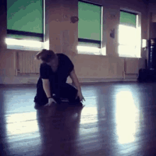 a woman is kneeling on the floor in a dark room