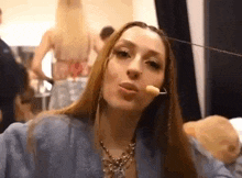 a woman with long hair is making a funny face while wearing a microphone .