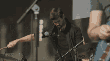 a man playing drums in front of a microphone with a sign that says stagecoach