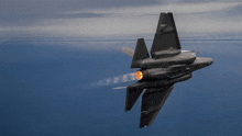 a fighter jet is flying through a cloudy sky with its tail visible