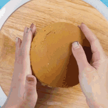 a person holding a piece of cake on a wooden cutting board with easy plus written on the bottom right