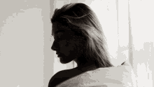 a black and white photo of a naked woman wrapped in a blanket .