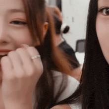 a close up of two women 's faces with one wearing a ring