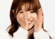a close up of a young woman making a funny face with her hands .