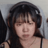 a close up of a woman wearing headphones and making a funny face .