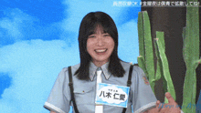 a woman in a police uniform is smiling and holding a sign that says ' aoi ' on it