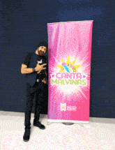 a man stands in front of a canta malvinas banner