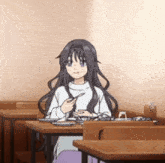 a girl with long black hair is sitting at a table with a spoon in her hand .