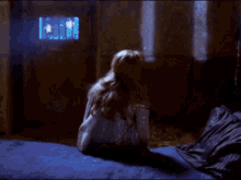a woman in a white dress is laying on a bed with her hands on her head .