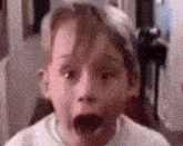a close up of a child 's face with his mouth open