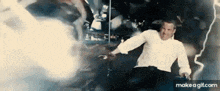 a man in a white shirt is standing in front of a lightning bolt in a dark room .