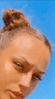a close up of a woman 's face with a blue background
