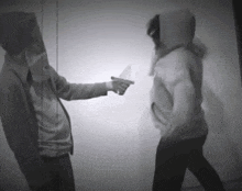 a man is pointing a knife at another man
