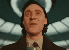 a man in a suit and tie is smiling and looking up at the camera .