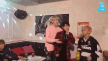 a group of young men are singing into microphones in a room .
