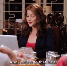 a woman sitting at a table with a laptop and the words and i object to that idea