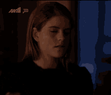 a woman 's face is shown in a dark room with the awt logo in the background