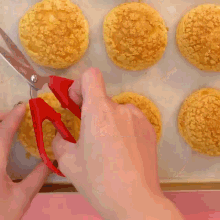 a close up of a person holding a pastry with a pink filling