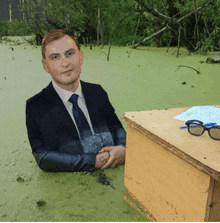 a man in a suit is sitting in a swamp