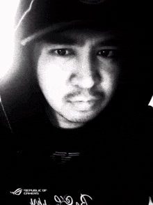 a black and white photo of a man with the republic of gamers logo on the bottom
