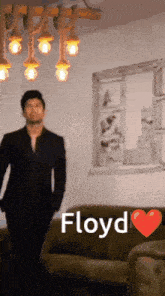 a man in a suit is standing in front of a couch with the name floyd written above him