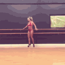 a woman in a red bikini and high heels is dancing