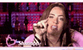 a woman named shannon is making a funny face while talking on a cell phone .
