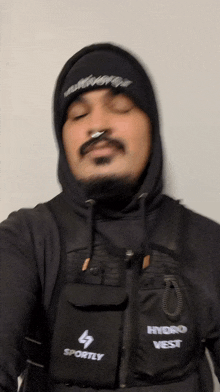 a man wearing a black vest that says sportly