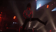 a man is jumping in the air on a stage with a microphone