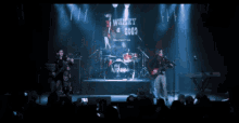 a band performs on stage with a sign that says whisky a gogo
