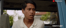 a man in a white shirt is sitting in the back seat of a blue van with the caption " terbaik ke langit "