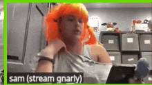 a woman wearing an orange wig is sitting in front of a computer .
