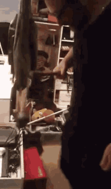 a man in a black shirt is using a hammer to hammer a piece of wood