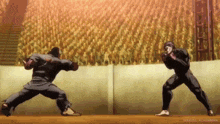 two men are fighting in a boxing ring in front of a crowd of people .