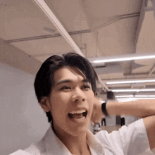 a young man in a white shirt is making a funny face with his mouth open