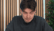 a man wearing a black sweatshirt with a microphone on his neck