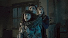 a man and two women are standing in a dark room