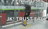 a man is standing in front of a bus with the words `` jk ! trust fall '' written on the screen .