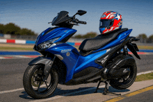 a blue scooter with 155 on the front is parked on the side of the road