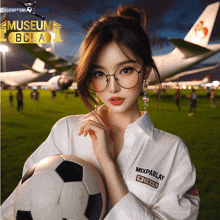 a woman wearing glasses holds a soccer ball in front of a sign that says " museum bola "