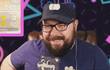 a man with a beard wearing glasses and a hat is smiling