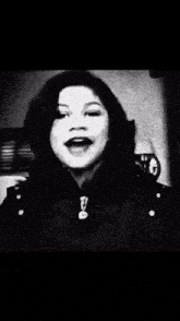 a black and white photo of a woman wearing a large hat in front of a sign that says teen
