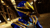 a person in a blue and gold costume with a helmet on