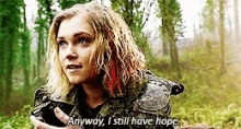a woman is standing in the woods holding a turtle and saying `` anyway , i still have hope . ''
